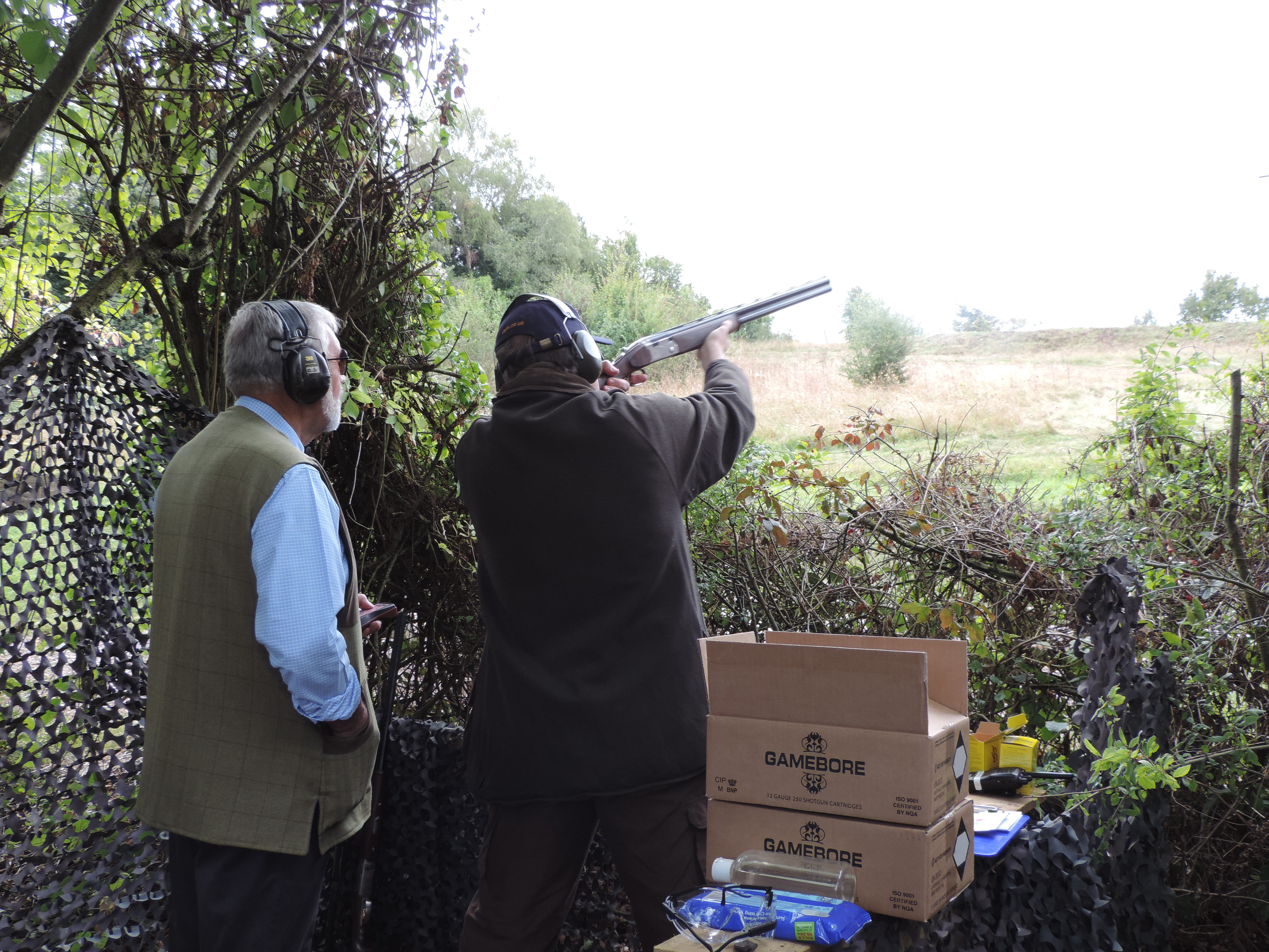 Two people clay shooting
