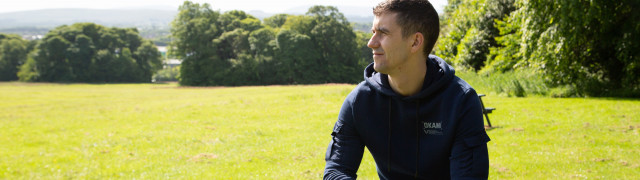 Veteran Steven sitting on bench in open green space
