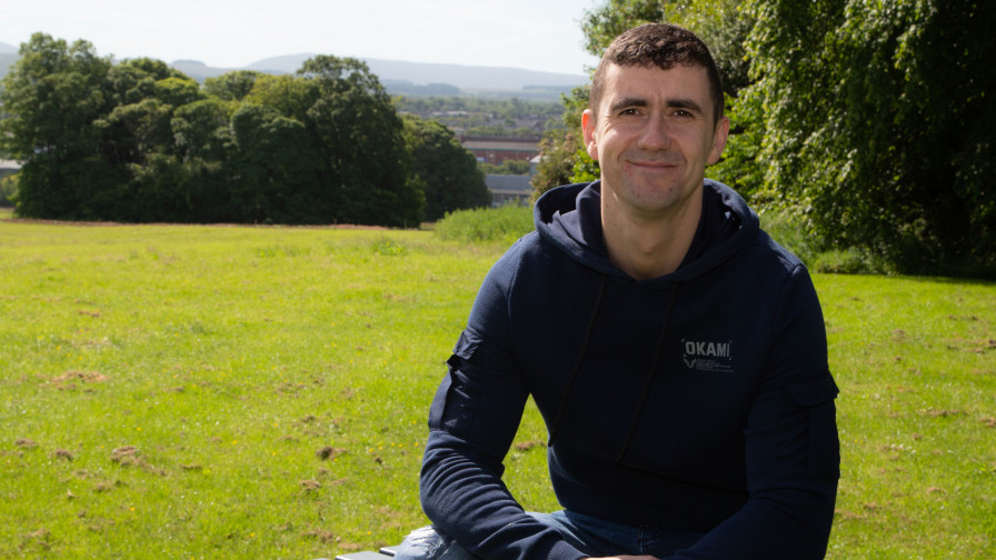 Veteran Steven sitting on bench in open green space