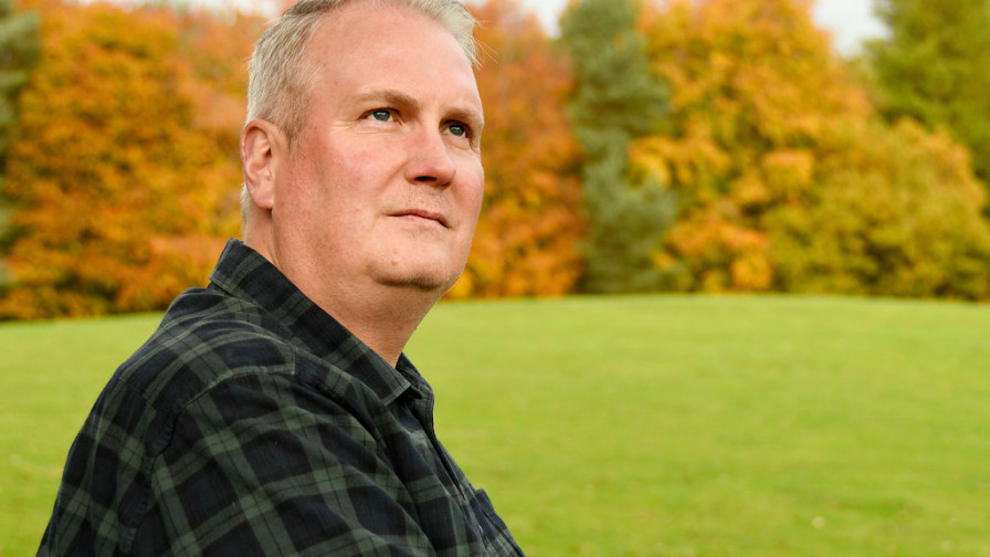 A photo of veteran Lee with an autumnal backdrop of grass and trees