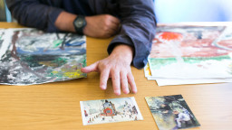 Man pointing at artwork on table