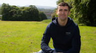 Veteran Steven sitting on bench in open green space