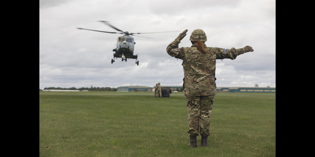 Female Air Trooper marshaling a helicopter.